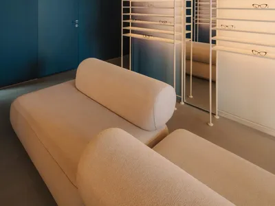 Comfortable living space with a blue accent wall, a couch, a chair, and a mirror, well-lit and inviting
