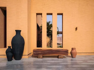 A warm and inviting living space with a wooden bench and vases, surrounded by natural light from a window