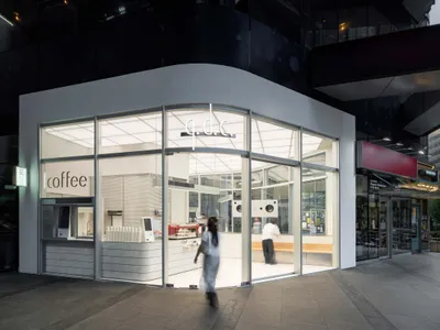 A casual coffee shop with a white exterior and glass door, well-lit and inviting