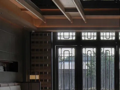 一間充滿光明的客廳，白色沙發、靠近大窗的椅子、木地板，讓自然光線進入空間