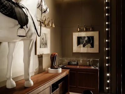 A room with a horse statue, wooden floor, and decorative items such as a chair, clock, and vase, creating an elegant atmosphere