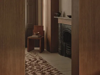 Cozy living room with a fireplace, chair, and dining table, featuring a warm and inviting atmosphere