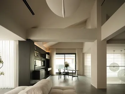 A well-lit living room with a couch, dining table, and kitchen area, featuring wood and glass materials and various decorative items