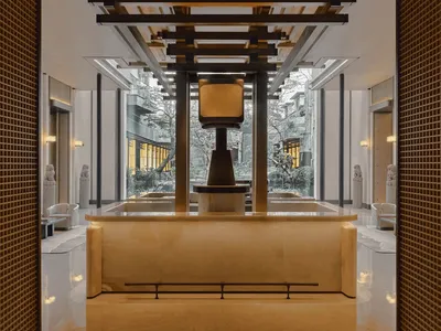 Modern lobby with a white marble countertop, chairs, and natural light from a large window