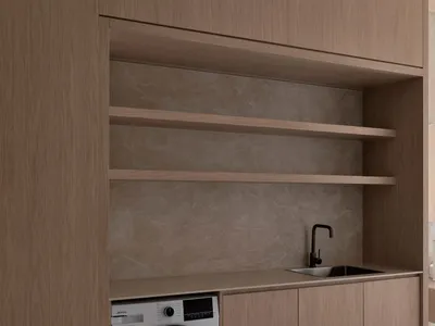 A modern kitchen with wooden cabinets, a white washer dryer, and a refrigerator, sink, and microwave, lit by natural sunlight