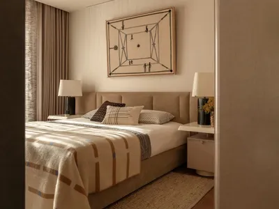 A well-lit bedroom with a bed, nightstand, and painting, featuring warm wood and fabric materials
