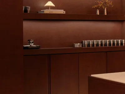 Cozy living space with a wooden shelf and brown wall, featuring various decorative items and a warm atmosphere