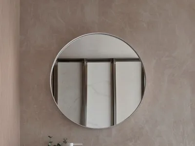 一間現代浴室，白色洗手池, 大圓形鏡子, 大理石 countertops, 設置在一間有木質鏡櫃的浴室, 在充足的照明下