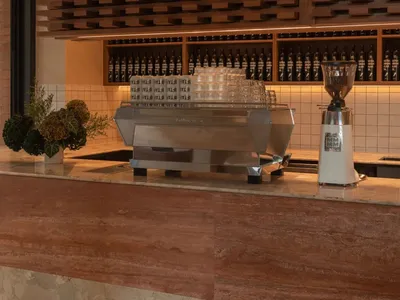 一間餐廳或咖啡館的木質主題的廚房，擺設著各種物品和一台咖啡機，環境光線柔和