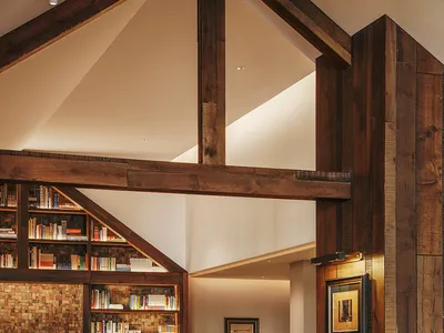 Cozy living room with a brick wall, wooden floor, and comfortable furniture, including a dining table, couch, and bookshelf, creating a warm and inviting atmosphere