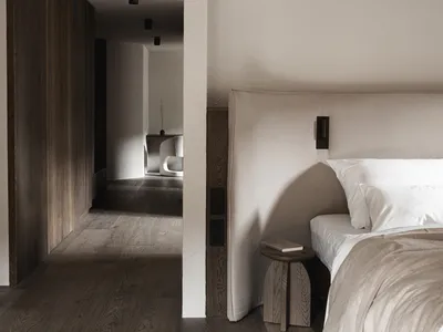 Cozy bedroom with a bed, chair, and bench, dimly lit with a simple and functional style
