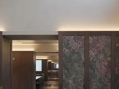 一間溫暖且引人入勝的用餐空間，擁有木地板和桌子，周圍舒適的座位和柔和的燈光