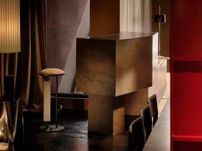 Cozy living room with a wooden floor, a red door, a dining table, a couch, and a counter