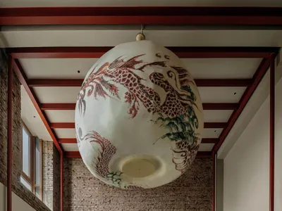 一間溫馨和溫暖的餐廳內部，brick牆、木頭家具和柔和的燈光，擁有高天花板的大空間，以及掛在牆上的藝術作品