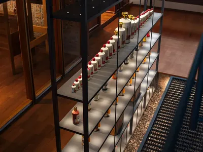 A cozy living space with a wooden shelf displaying bottles, soft warm lighting, and a inviting atmosphere