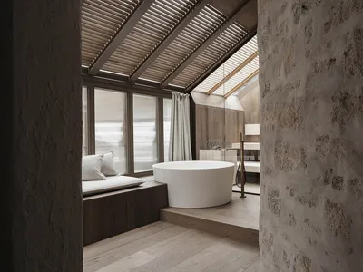 Dimly lit bathroom with a white bathtub, wooden accents, and a sink to the right of the bathtub