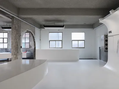 一間現代廚房，白色工作台、水槽、冰箱，充滿自然光線，創造出一個平靜和溫馨的環境