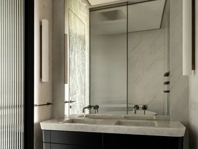 Classic bathroom with a marble sink, glass shower, and black and white color scheme, featuring dim lighting for a cozy atmosphere