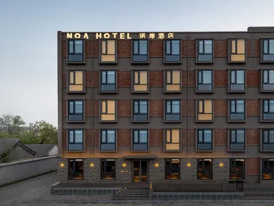 Photograph of a modern hotel with a brick facade, large windows, and a contemporary design