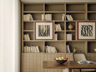 A well-lit living room with a wooden table and chairs, surrounded by books, creating a cozy and intellectual atmosphere