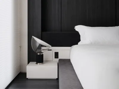 Cozy bedroom with a black bed frame, white comforter, and natural light from a window with white curtains
