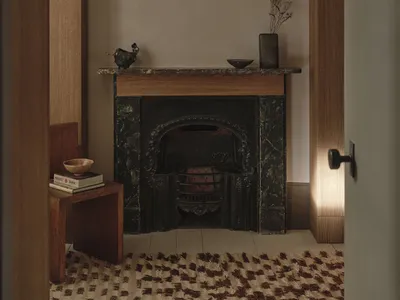 舒適的客廳有一個石頭 fireplace、白色的燈泡和散落的書籍，營造出溫暖而令人愉悅的氛圍
