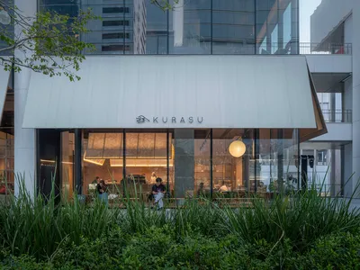 充滿自然光線的現代餐廳，木質和金屬元素，擠擁著人們和家具