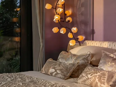 Cozy bedroom with a white comforter, a hanging lamp, and natural light from an open window