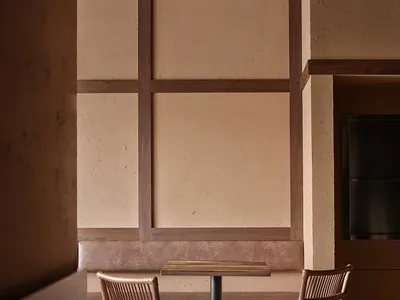 A warm and inviting dining area with a table surrounded by chairs and a bench, well-lit by natural light through the windows