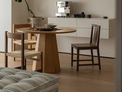 A warm and inviting dining area with a wooden table and chairs, surrounded by a kitchenette in the background