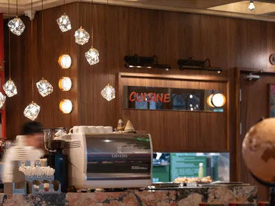 Cozy restaurant dining area with wooden furniture, a table, and dim lighting, creating an intimate atmosphere