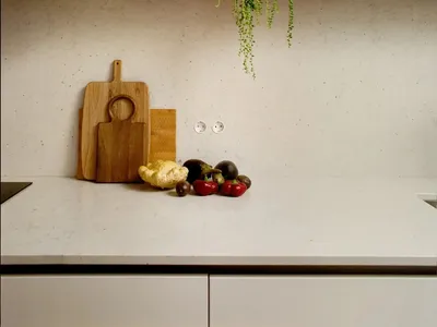 A well-lit kitchen counter displaying a variety of fresh fruits and vegetables on a marble surface