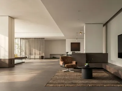 Cozy living room with a modern design, featuring a flat screen TV, couch, and chair, decorated with potted plants and warm soft lighting