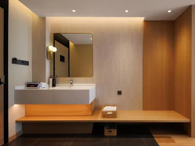 Bathroom with a white sink, wooden walls, and a mirror above the sink in a dimly lit space