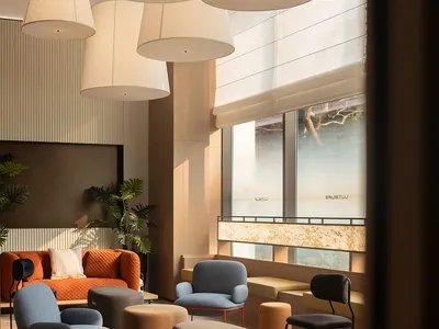 A modern living room with a large window, natural light, and a mix of wood and fabric elements, featuring a couch, chair, bench, and dining table, with a clean and minimalist design