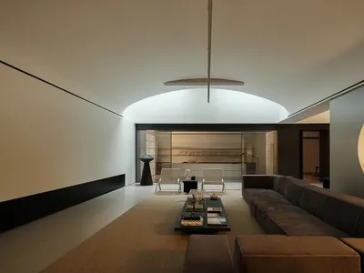 Comfortable living room with a large couch, coffee table, and chair, set against a brown background with a rug and well-lit atmosphere