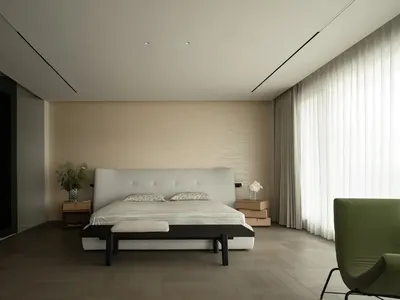 一間明亮的現代臥室，白色床框，黑色框架，擺放了一個花瓶的書桌，與清潔的背景