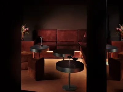 Cozy living room with brown furniture, a red curtain, and dim lighting