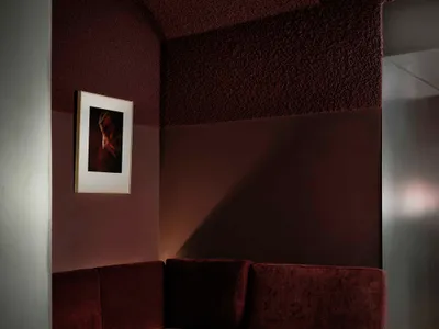 Cozy living room with a brown couch, a chair, and a table, dimly lit for a relaxing atmosphere