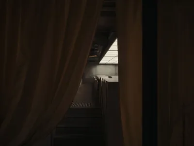 一間溫暖並令人吸引的餐廳區域，具有半圓形座位佈局並有一個黃色窗簾遮蓋著門口