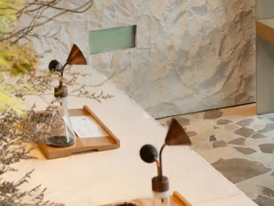 Bathroom with stone countertop and walls, sink, and toilet, dim lighting creating a cozy atmosphere