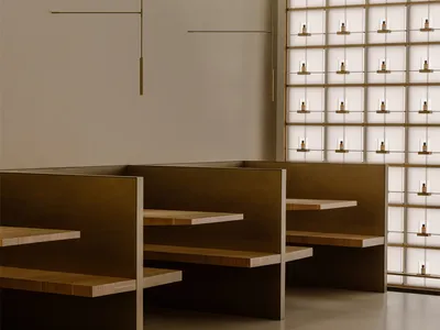 A modern restaurant with a large dining area featuring wooden tables and metal chairs, well-lit and inviting