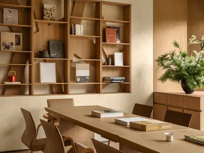 A warm and inviting dining area with a wooden table and chairs, a potted plant, and a book on the table