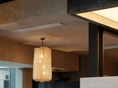 A cozy restaurant with a dining table and chairs, surrounded by wood and fabric, with a dimly lit atmosphere
