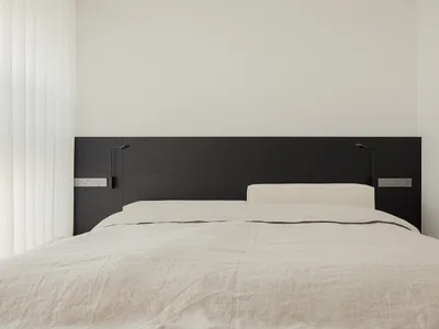 Cozy minimalist bedroom with a bed, nightstand, and dim lighting