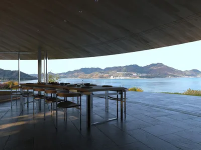 一間充滿自然光線的餐廳，擺放著木頭桌椅，周圍有大型窗戶，透過窗戶可以看到外面的景色和水體