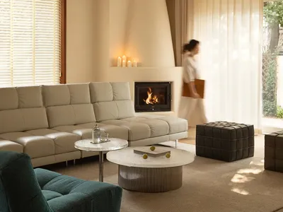 Cozy living room with a fireplace, white furniture, and natural light