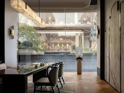 A modern restaurant with a large window, a dining table, chairs, and various table settings, set in a well-lit space with natural light