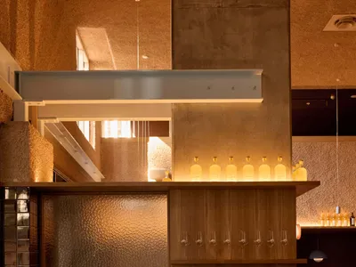 木質牆、地板和家具的溫暖和邀人的餐廳，酒吧中充滿酒杯和瓶子，自然光線照進