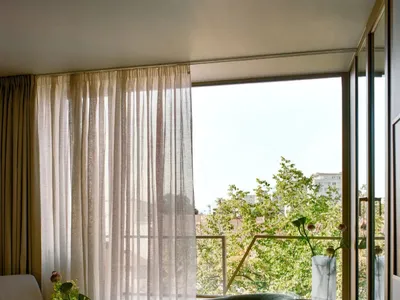 舒適的客廳，擺放了一個沙發、椅子、餐桌和花瓶，採用木材和玻璃材料，充足的燈光營造出溫暖的氣氛